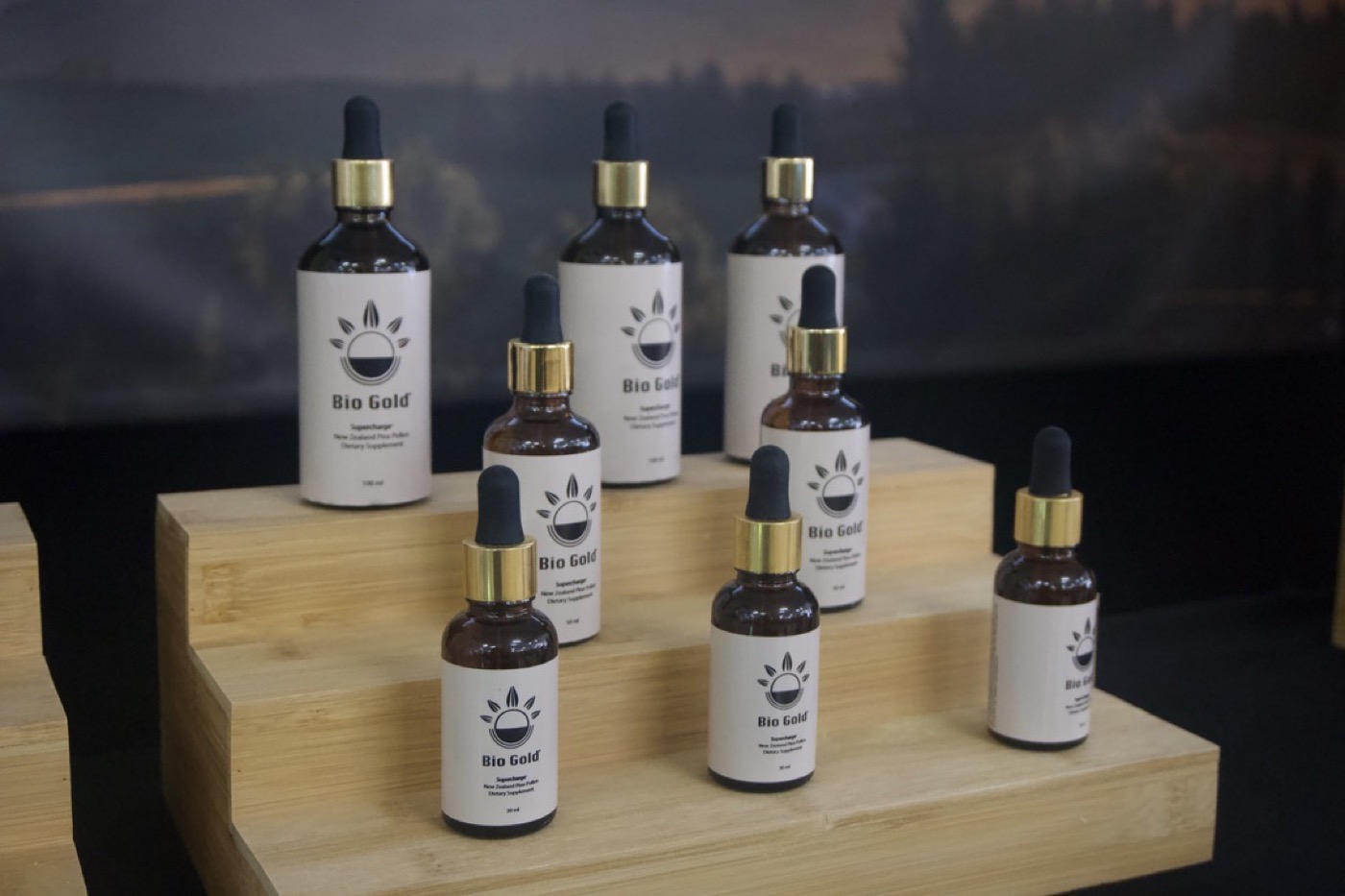 Biogold bottles displayed on a wooden product stand
