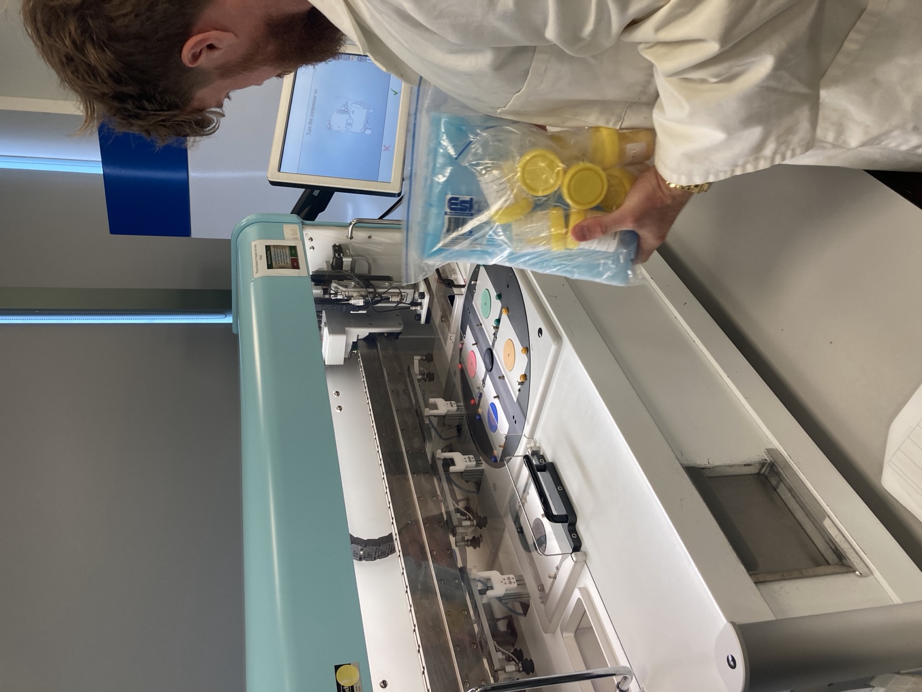 Carl Meyer in a lab coat with Biogold bottles and filling equipment